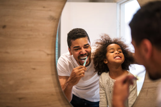 Family brushing teeth in mirror