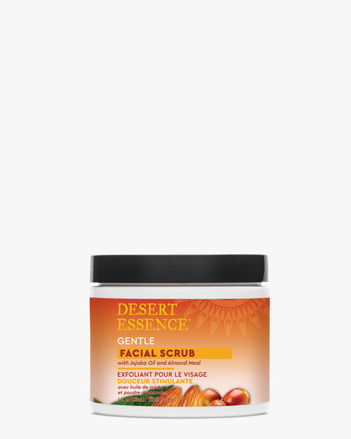 Desert Essence Gentle Facial Scrub jar with orange gradient label shown against white background, featuring natural exfoliants and plant oils for skin brightening and smoothing