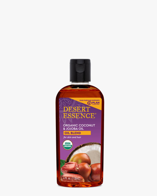 Desert Essence Organic Coconut & Jojoba Oil blend in a clear amber bottle with purple label. Natural skincare product featuring fresh coconut and jojoba ingredients displayed on front. USDA organic certified beauty oil for skin and hair care.