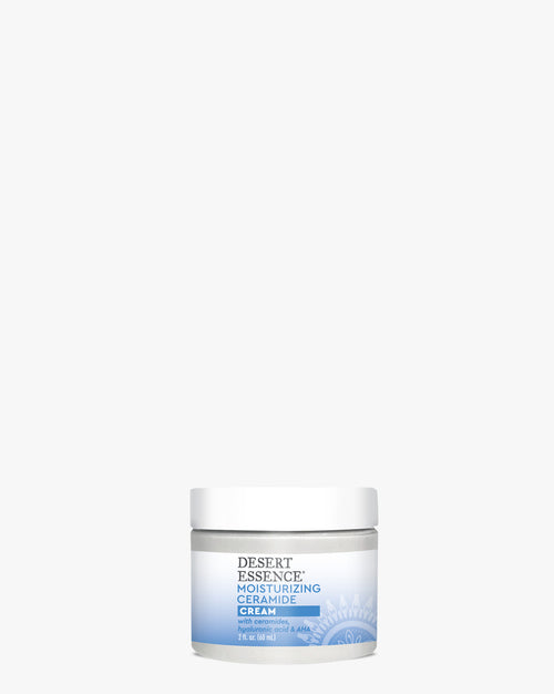 A white jar of Moisturizing Ceramide Cream from Desert Essence against a white background, featuring a blue gradient label design and professional skincare packaging