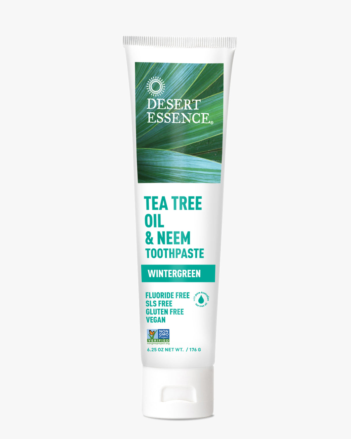 Desert Essence Tea Tree Oil & Neem Wintergreen Toothpaste shown in white tube packaging with green palm leaf background design. Natural fluoride-free formula featuring botanical ingredients for oral health and fresh breath.