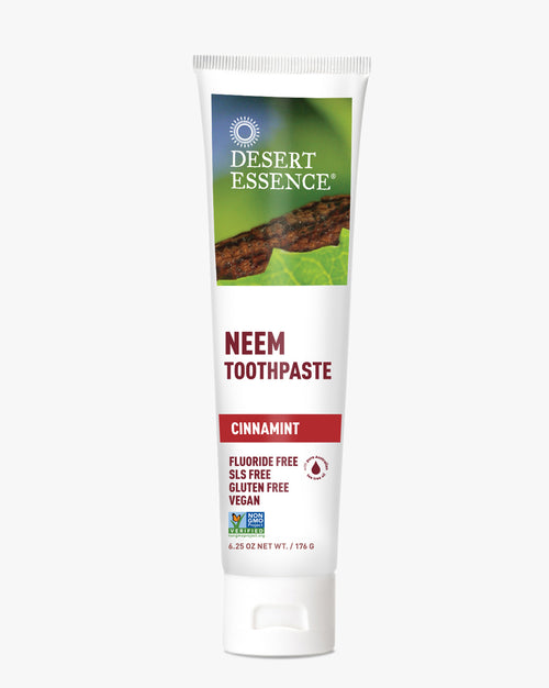 Desert Essence Neem Toothpaste in Cinnamint flavor shown in a white tube with green branding. Features natural ingredients and is fluoride-free, SLS-free, gluten-free, and vegan, displayed against a white background.