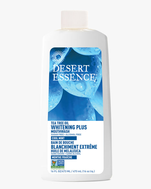 Desert Essence Tea Tree Oil Whitening Plus Mouthwash in a white plastic bottle with blue label featuring water droplet design, showing natural and alcohol-free formula for teeth whitening and fresh breath