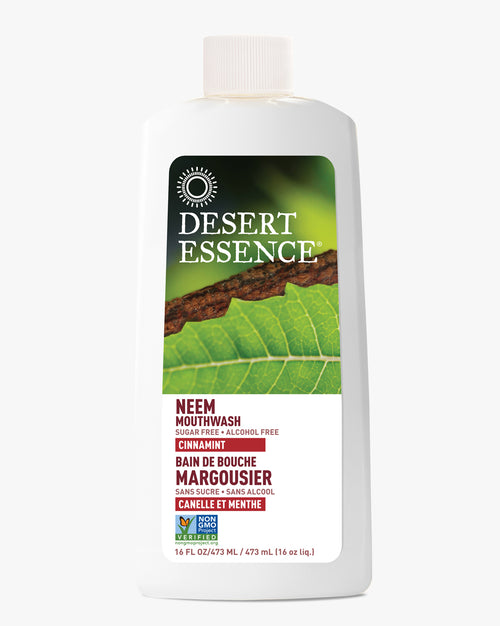 Desert Essence Neem Mouthwash Cinnamint bottle with natural green leaf background, featuring white and red label design, showcasing natural oral care product in white plastic container with beige cap