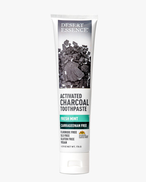 Desert Essence Activated Charcoal Carrageenan Free Toothpaste tube showing white packaging with charcoal imagery, featuring fresh mint flavor and multiple free-from claims including fluoride-free, gluten-free, and vegan labeling