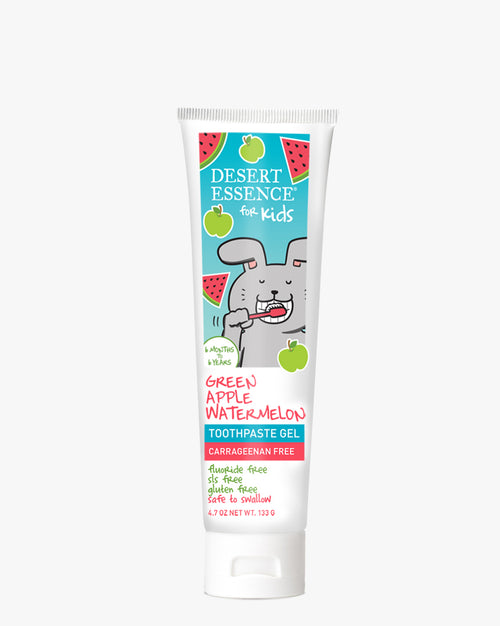 Desert Essence Green Apple Watermelon Kids Toothpaste Gel tube featuring a cartoon bunny illustration on turquoise packaging with watermelon and apple motifs, designed for children's dental care. Safe-to-swallow formula in a white squeeze tube with colorful text.