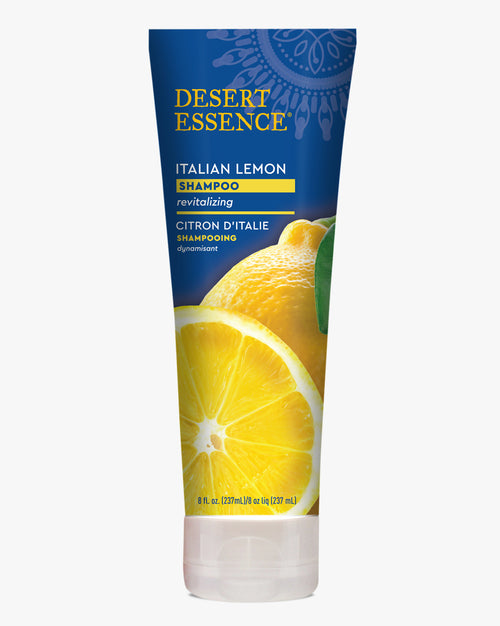 Desert Essence Italian Lemon Shampoo tube featuring vibrant yellow sliced lemon imagery on deep blue packaging with gold lettering, displaying bilingual English and French text for this revitalizing hair care product