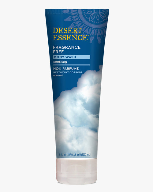 Desert Essence Fragrance Free Body Wash tube featuring a navy blue gradient design with cloud imagery, English and French text, and gold brand lettering on a clean white background. Gentle soothing formula in an 8 fl oz squeeze tube packaging.