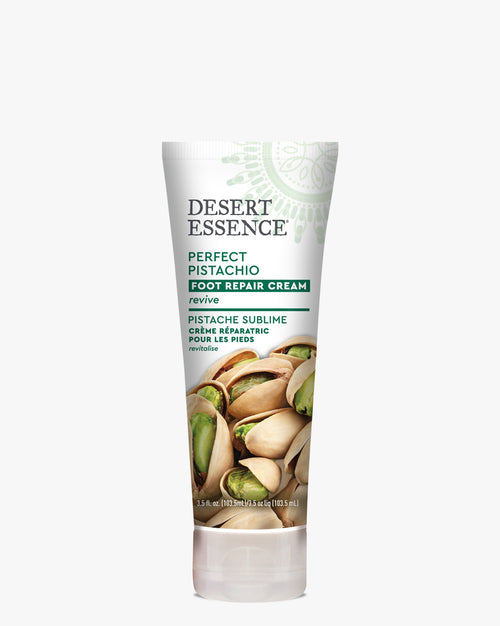 Desert Essence Perfect Pistachio Foot Repair Cream in a white tube with green accents, featuring fresh pistachio nuts imagery on packaging. Product showcases bilingual English-French labeling and organic skincare branding.