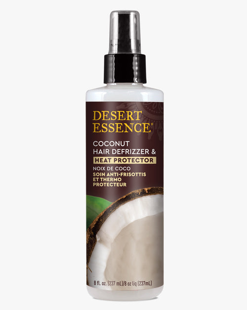 Desert Essence Coconut Hair Defrizzer & Heat Protector Spray bottle with brown and white label design, featuring a coconut image in the background and clear spray nozzle top. White spray bottle contains 8 fl oz of hair protection formula.