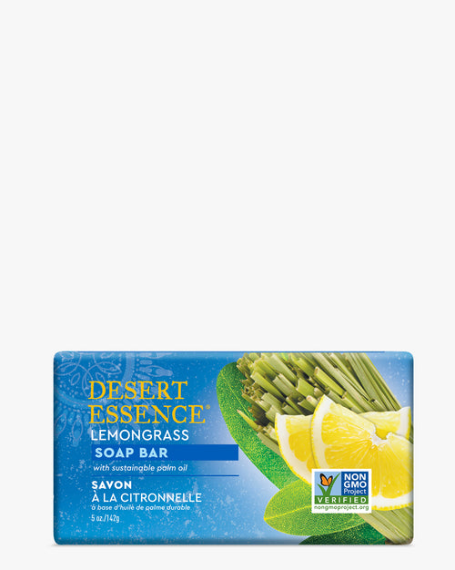 Desert Essence Lemongrass Soap Bar displayed on blue packaging with fresh lemongrass stalks and lemon slices, featuring non-GMO certification and sustainable palm oil labeling. Natural soap bar with vibrant yellow and green imagery.